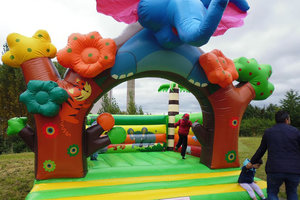 Bunte Hüpfburg mit Tiermotiven sorgt für Spaß bei den Kindern auf dem Nachbarschaftsfest.