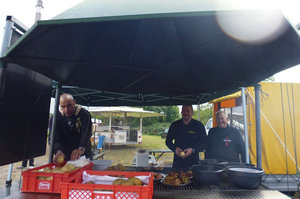 Freiwillige bereiten Grillwürstchen für die Gäste des Festes zu.