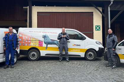 Drei Handwerker stehen vor einem Servicefahrzeug der BWG mit auffälliger Werbegrafik – Einsatzbereit für Hausmeisterdienste im Harzkreis