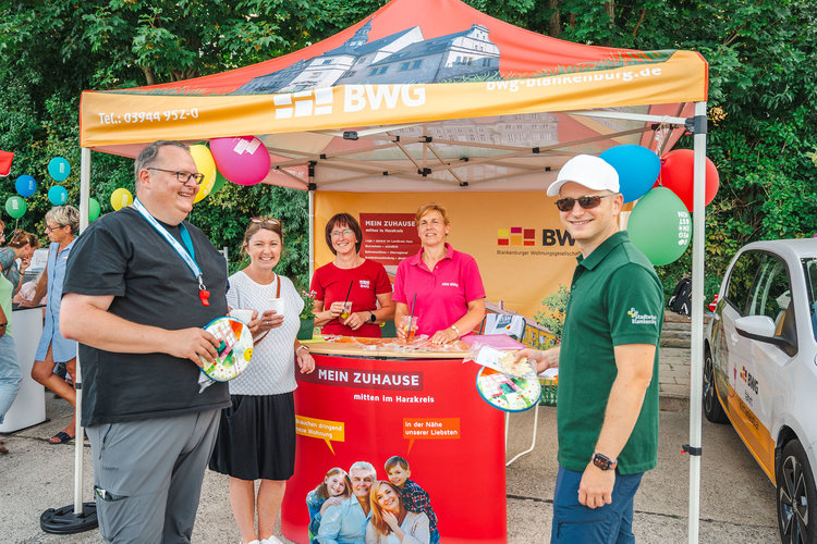Informationsstand der Blankenburger Wohnungsgenossenschaft (BWG) beim Stadtteilfest in Regenstein – Mitarbeitende im Gespräch mit Besucherinnen und Besuchern über Wohnangebote im Harzkreis.
