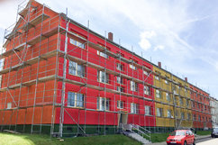 Mehrstöckiges Wohngebäude in der Börnecke Straße 36 bis 38 im Quartier Regenstein während der Sanierung, eingerüstet und mit farbenfroher Fassadengestaltung in Rot-, Orange- und Gelbtönen.