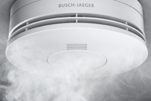 Ein Rauchwarnmelder in weiß oben an der Decke mit weißem sichtbaren Rauch