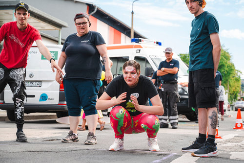Junge Erwachsene nehmen aktiv an einem inklusiven Straßenspiel beim Stadtteilfest im Quartier Regenstein teil – mit buntem Make-up, sportlicher Aktion und viel Gemeinschaft.