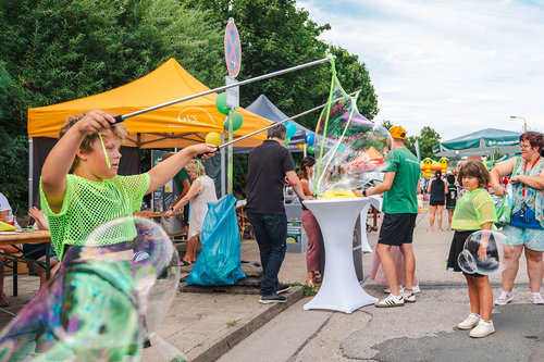 Kinder spielen mit Riesenseifenblasen beim Nachbarschaftsfest im Quartier Regenstein – buntes Treiben, Mitmachaktionen und Sommerstimmung auf der Straße.