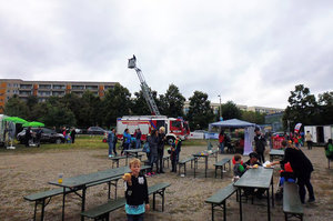 Festplatz mit Feuerwehr-Drehleiter und Besuchern bei Mitmachaktionen im Wohngebiet.