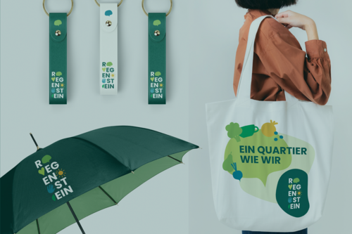 Werbemittel für das Quartier Regenstein: bedruckte Schlüsselanhänger, Regenschirm und Stofftasche mit dem Slogan „Ein Quartier wie wir“ und dem Regenstein-Logo
